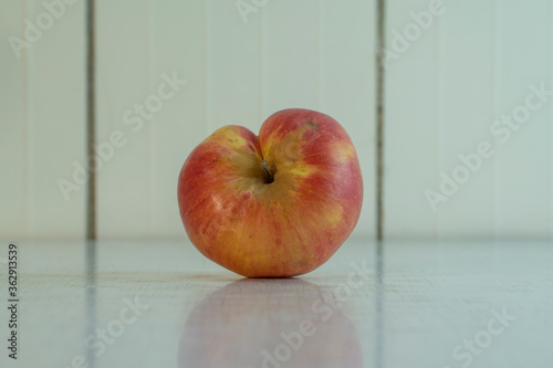 Misshapen Siamese twins apple on the white table in kitchen. Village fruit is good for healthy nutrition. it's contain many vitamins and microelements. Horizontal image with copy space.