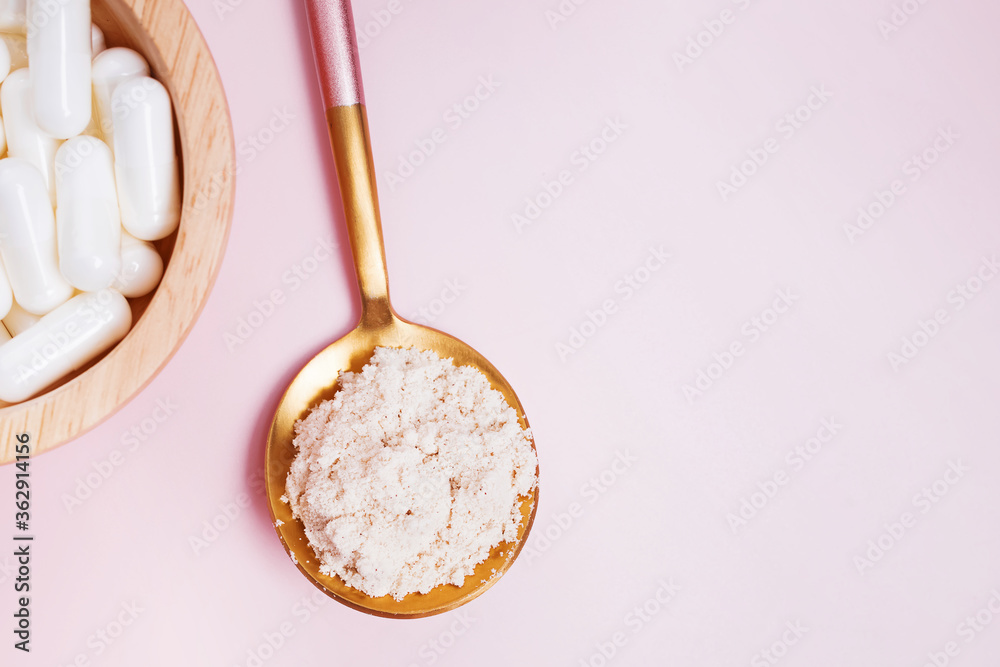 Collagen powder and pills on pink background Collagen powder and pills on pink background