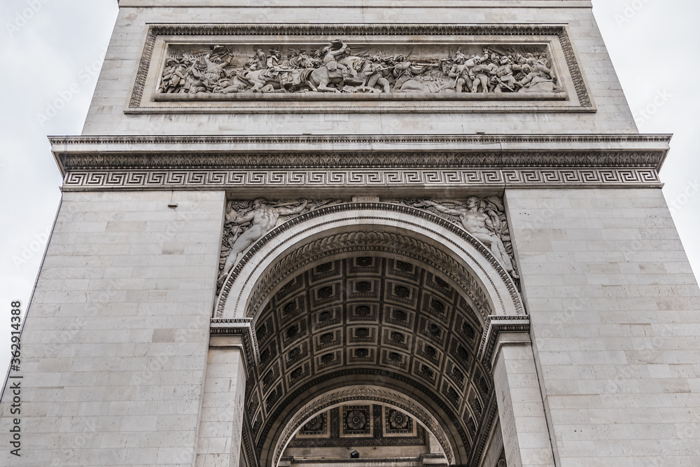 Architectural fragment of Arc de Triomphe. Arc de Triomphe de l'Etoile on Charles de Gaulle Place is one of the most famous monuments in Paris. France. Architectural fragment of Arc de Triomphe. Arc de Triomphe de l'Etoile on Charles de Gaulle Place is one of the most famous monuments in Paris. France.