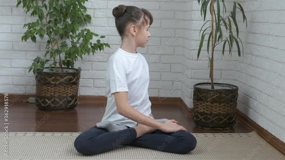 Performing fitness at home. A young girl in the lotus position meditates. Performing fitness at home. A young girl in the lotus position meditates.