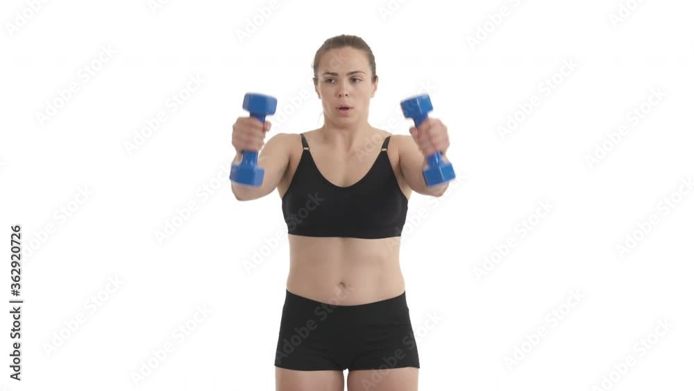 Front view portrait of young athlete woman working out deltoid muscle with dumbbells. Isolated on white background. Front view portrait of young athlete woman working out deltoid muscle with dumbbells. Isolated on white background.