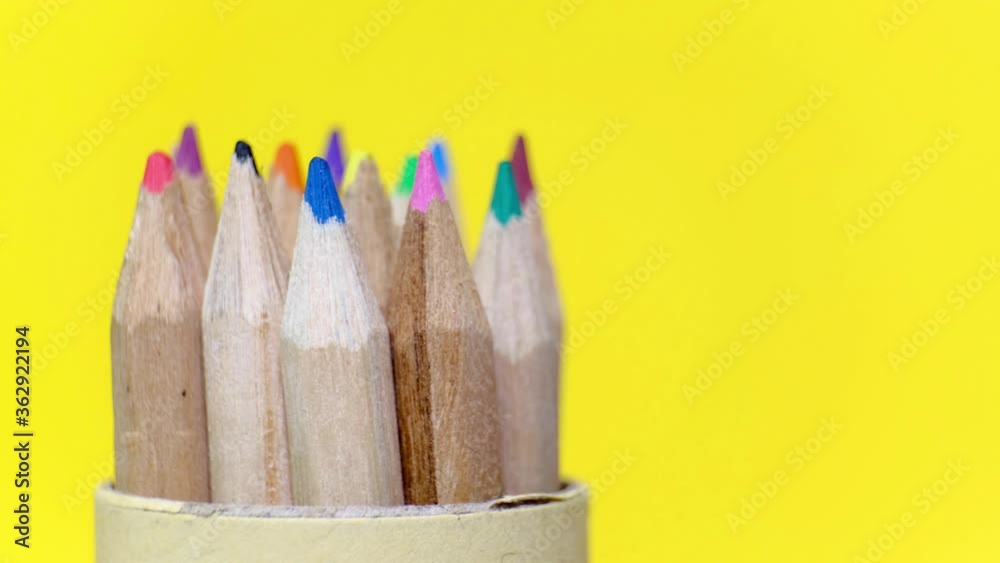 Closeup set of colored wooden pencils in different colors rotating on yellow background. Isolated object with copy space. Back to school concept. Closeup set of colored wooden pencils in different colors rotating on yellow background. Isolated object with copy space. Back to school concept.