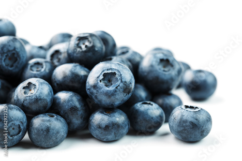Tasty blueberries fruit are scattered on a white background.