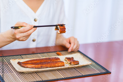 Japanese middle aged woman eats grilled Unagi photo