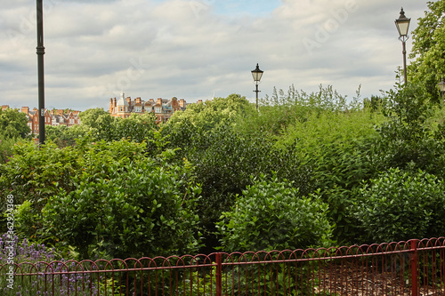 Greenery, lighthouse and castle with iron fence. photo