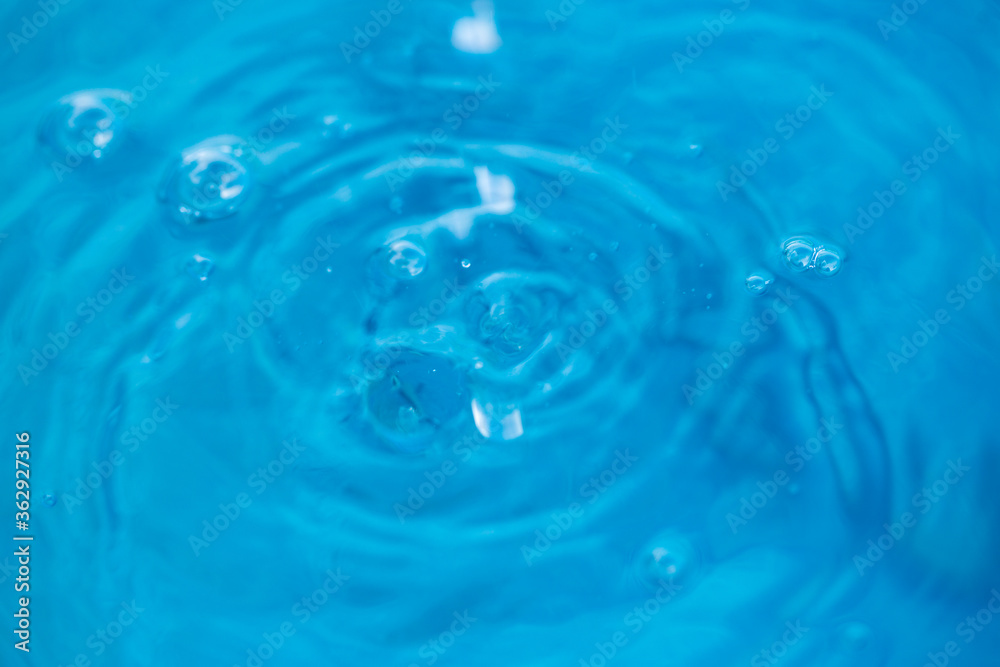 The round transparent drop of water, falls downwards. Selective focus.