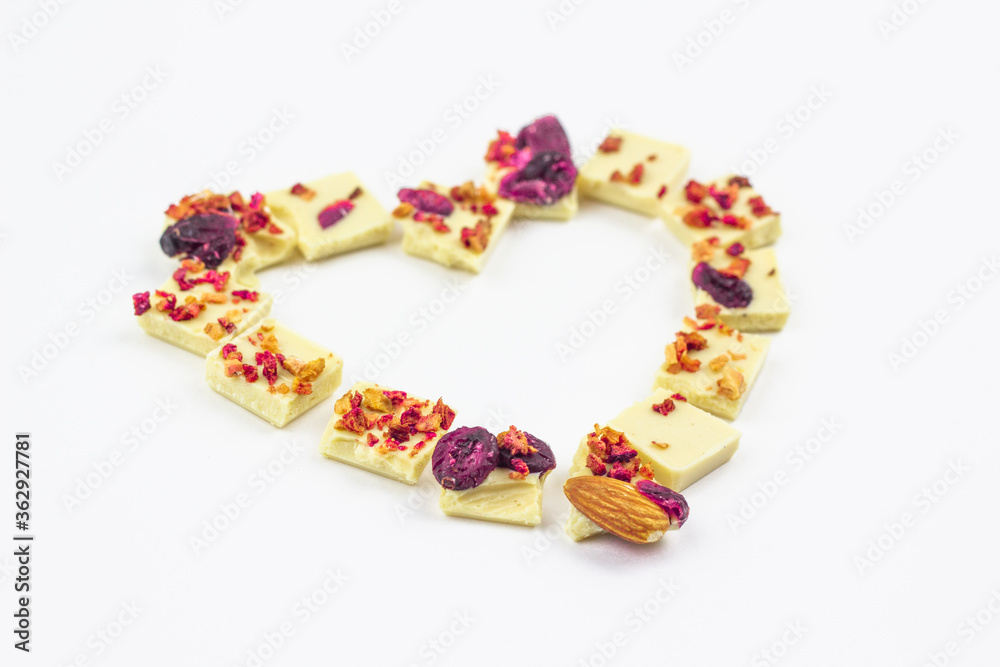 White chocolate with dried berries, fruits and almonds in the shape of a heart. White chocolate with dried berries, fruits and almonds in the shape of a heart.