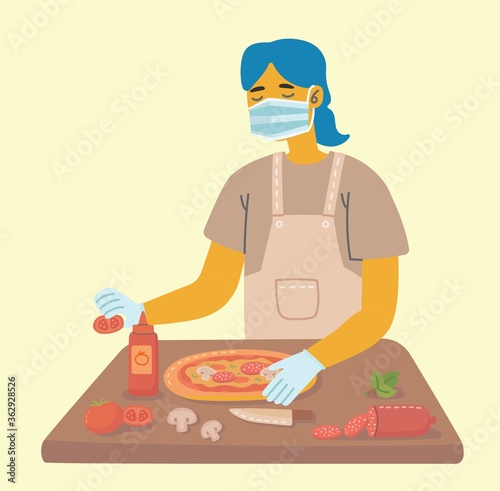 A housewife or woman in restaurant in a medical mask prepares pizza. Coronavirus epidemic.