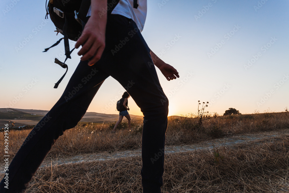 Ground level shot of young backpacker woman walking with teenager at ...