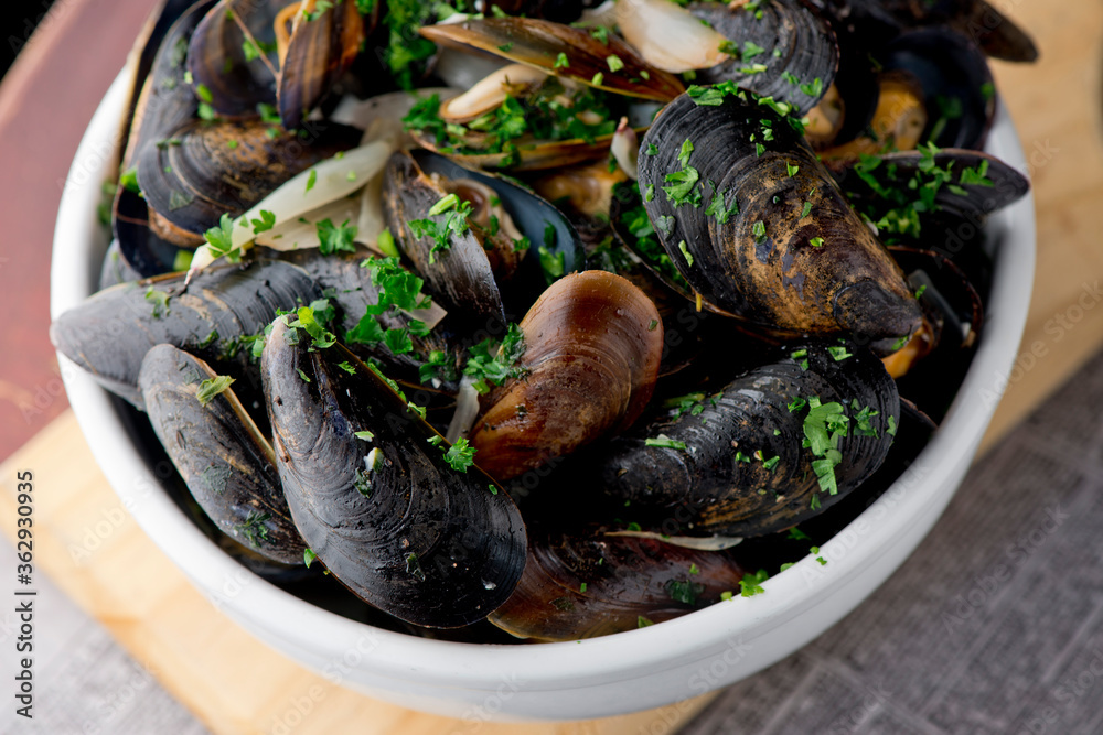 Mussels. Classic French or American restaurant appetizer: steamed mussels. Shellfish steamed with white wine, butter, garlic, onions and fresh herbs. Served with butter toasted baguettes. Mussels. Classic French or American restaurant appetizer: steamed mussels. Shellfish steamed with white wine, butter, garlic, onions and fresh herbs. Served with butter toasted baguettes.