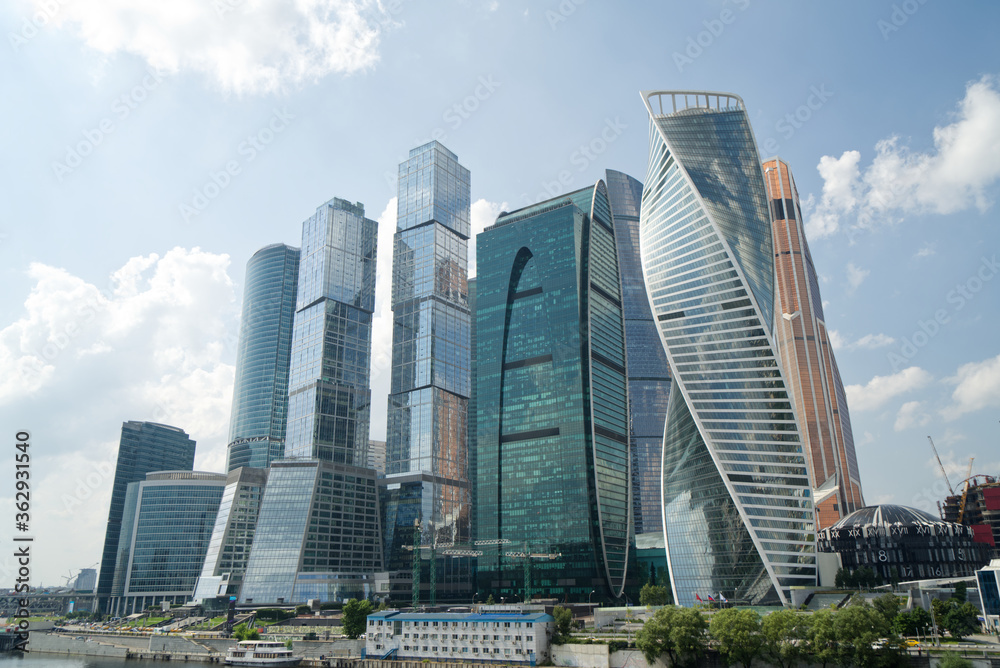 Naklejka premium modern skyscrapers business center with blue sky and clouds, reflections on glass, Moscow city