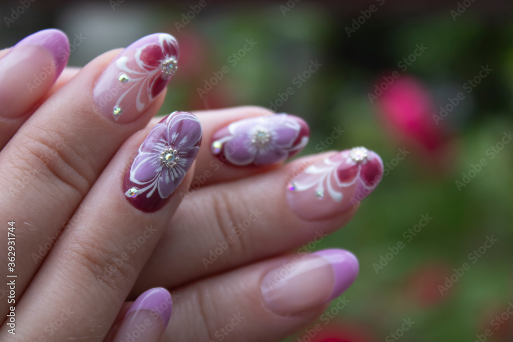  Ready beautiful manicure for a woman. Painted pink flowers. Concept of doing manicure. beauty concept. Gel polish, shellac. High quality photo