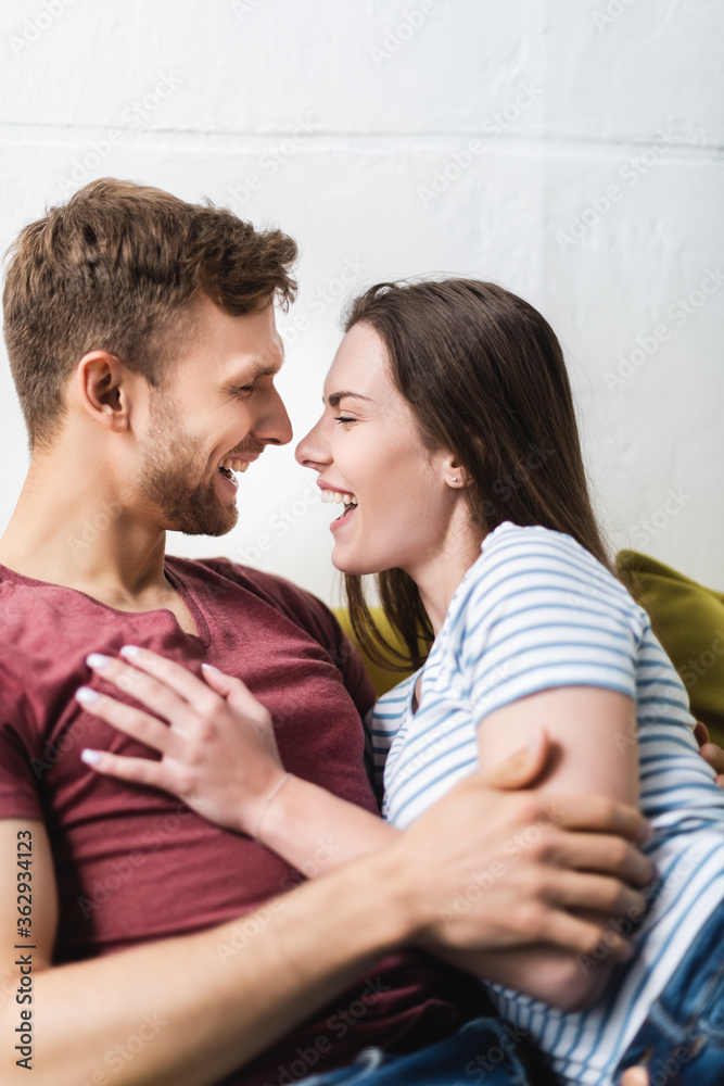 laughing beautiful young couple hugging at home laughing beautiful young couple hugging at home