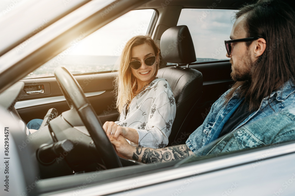 Young Stylish Traveling Hipsters Having Fun Sitting in Modern Car, Travel and Road Trip Concept