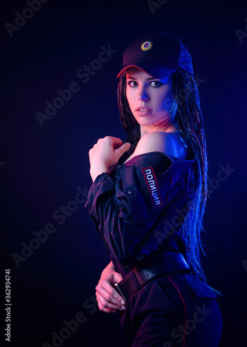 a girl in a police uniform with dreadlocks in neon light with chains and handcuffs English translation the police