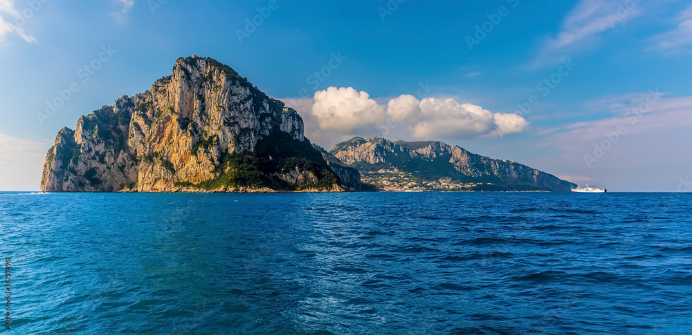 The steep cliffs of the Island of Capri, Italy on the horizon on a sunny morning