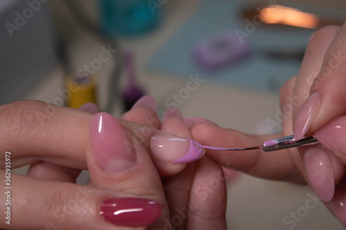 the process of doing manicure. Closeup of hands of professional manicurist  applying nail polish. Concept of doing manicure and fingernails cleaning. beauty concept. Gel polish  shellac