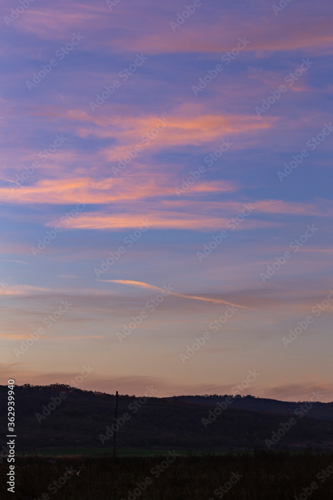 Purple-magenta clouds. Landscape with bloody  dawn. The terrain in southern Europe.  Panorama. Mirror lake with a reflection of nature. Morning silence. Water surface.