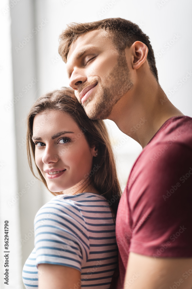 beautiful smiling young couple hugging at home