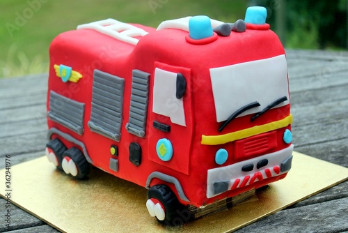 Closeup shot of a red fire truck cake on a wooden table