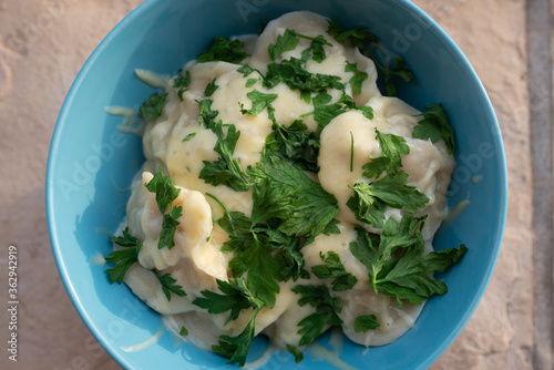 Homemade dumplings, traditional dumplings with meat, greens and cheese. Laid on a clay plate.