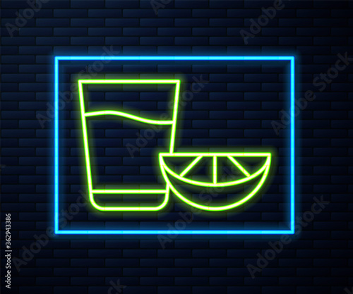 Glowing neon line Tequila glass with lemon icon isolated on brick wall background. Mexican alcohol drink. Vector.