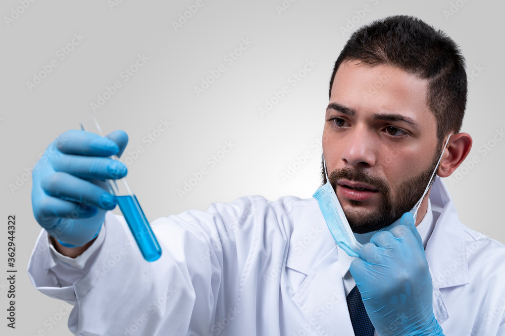 Bearded scientist or doctor in eyeglasses working at laboratory. Surprised technologist holding a test tube with samples. Experiment in lab. Scientific discovery. Bearded scientist or doctor in eyeglasses working at laboratory. Surprised technologist holding a test tube with samples. Experiment in lab. Scientific discovery.