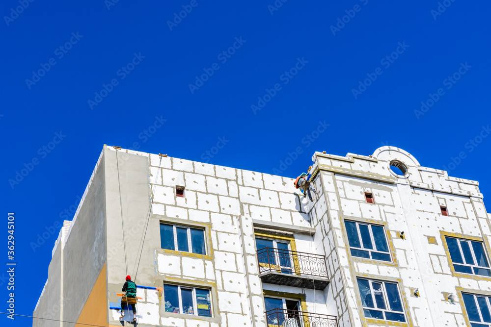 Insulation of the multistory residential building with styrofoam. Rope ...
