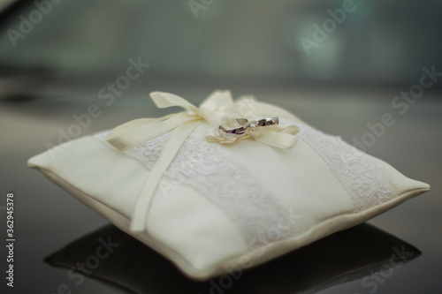 wedding rings on a white pillow