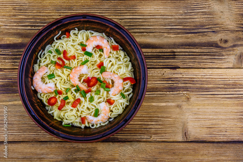 Instant noodle with shrimps, red pepper and green onion in a ceramic bowl. Japanese food. Top view