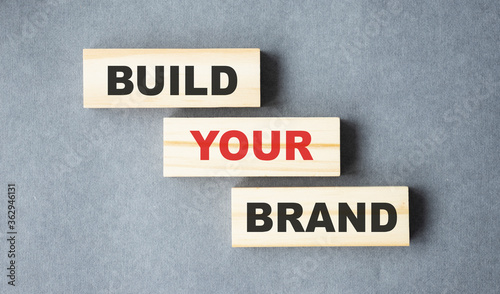 Build your Brand written on wooden blocks with vintage styled background. Branding rebranding marketing concept. © Inna