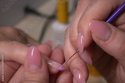 the process of doing manicure. Closeup of hands of professional manicurist  applying nail polish. Concept of doing manicure and fingernails cleaning. beauty concept. Gel polish  shellac