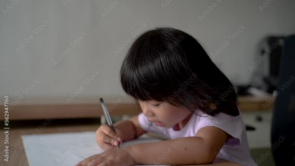little girl drawing in a drawing book using a pen little girl drawing in a drawing book using a pen