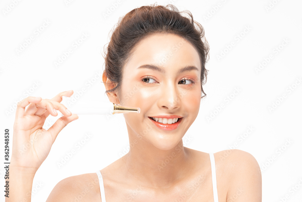 Beautiful Young Asian Woman Holding luxury white clean tube smile feeling so happy and cheerful with healthy Clean and Fresh skin,isolated on gray background,Beauty Cosmetics spa and treatment Concept Beautiful Young Asian Woman Holding luxury white clean tube smile feeling so happy and cheerful with healthy Clean and Fresh skin,isolated on gray background,Beauty Cosmetics spa and treatment Concept