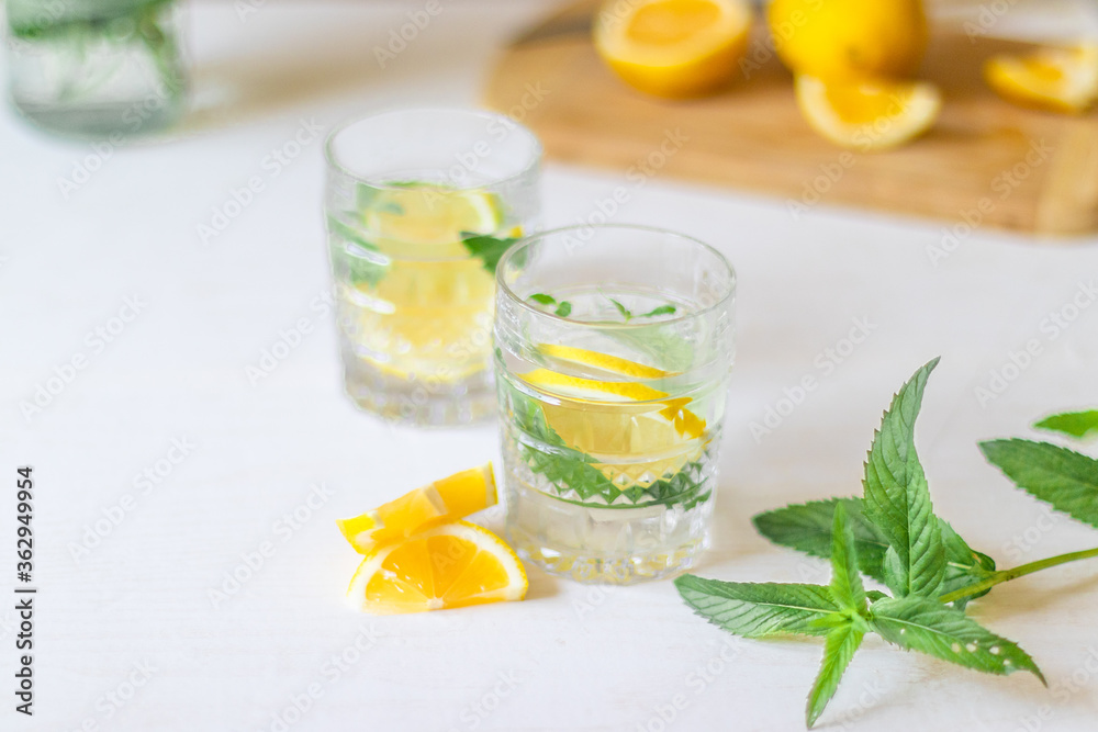 Fototapeta premium Top view of refreshing lemonade with slices of fruits in glass of drink with ice on white background for summer party. Summer drinks with ice