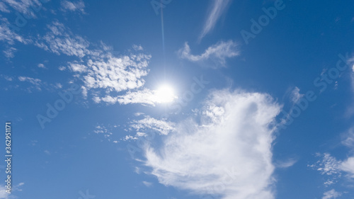 white cumulus clouds on a blue sky, bright sunny day, beautiful natural landscape