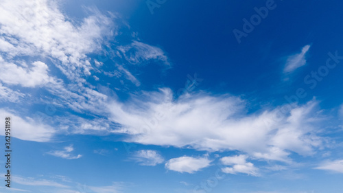 white cumulus clouds on a blue sky, bright sunny day, beautiful natural landscape