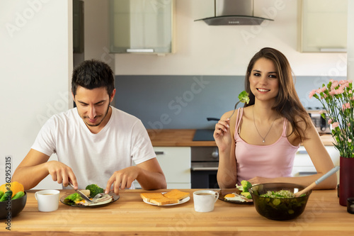 A young married couple having breakfast at home.