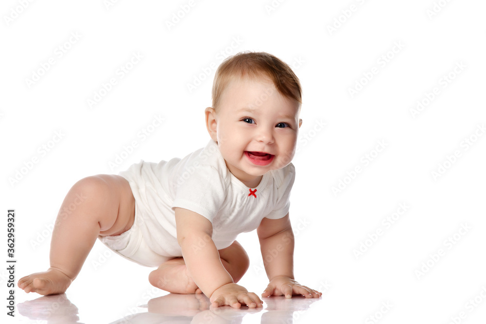 Adorable little baby infant in white cotton body creeping on floor, smiling and looking at camera
