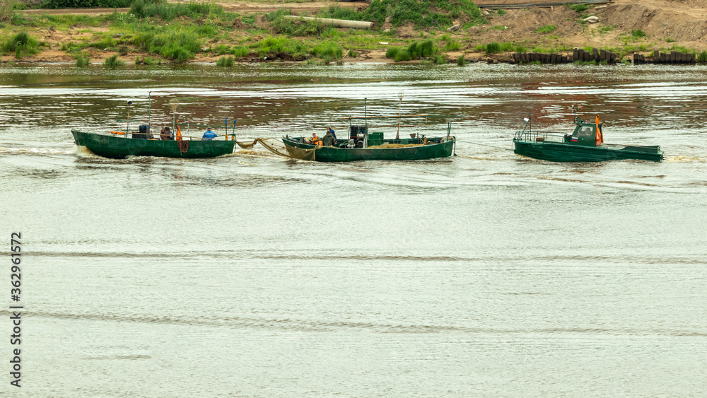 Obraz premium three fishing boats are sailing along the coast