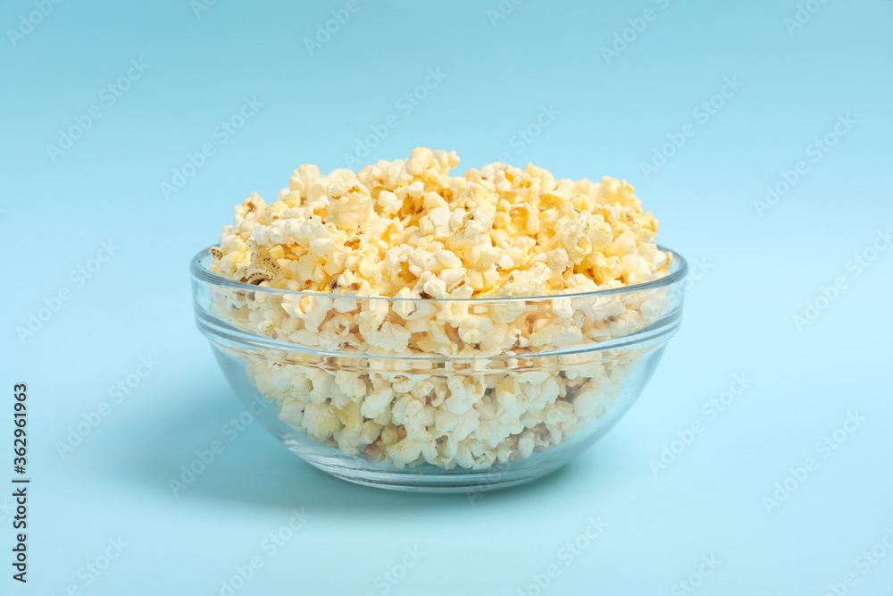 Bowl with popcorn on blue background. Food for watching cinema Bowl with popcorn on blue background. Food for watching cinema