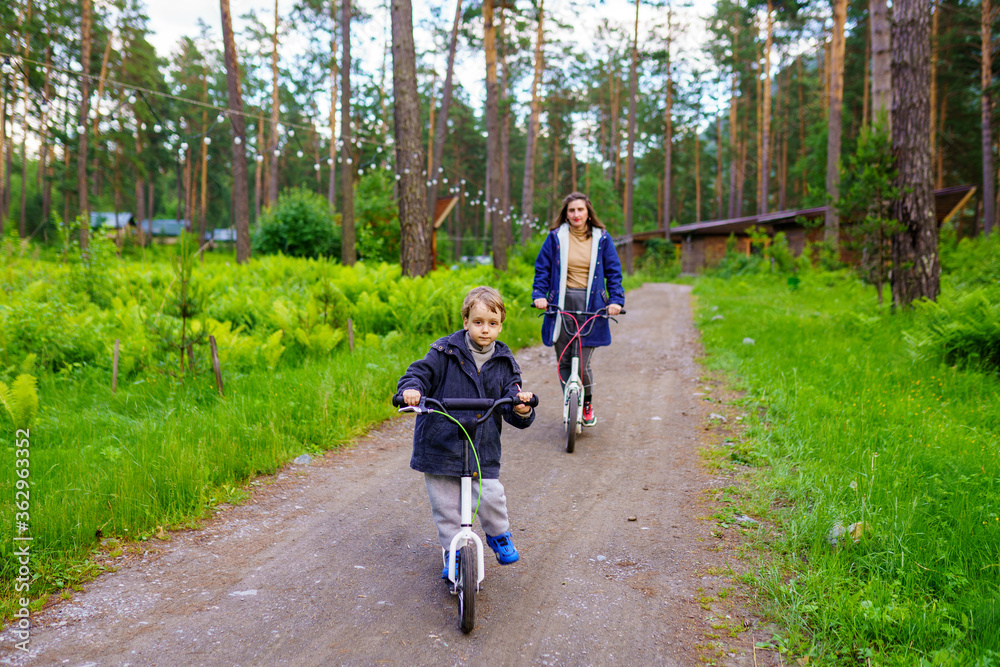 Obraz premium family riding on push scooters