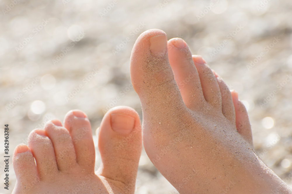 Close-up of baby's feet covered with sand. Relax on the sea beach. Close-up of baby's feet covered with sand. Relax on the sea beach.