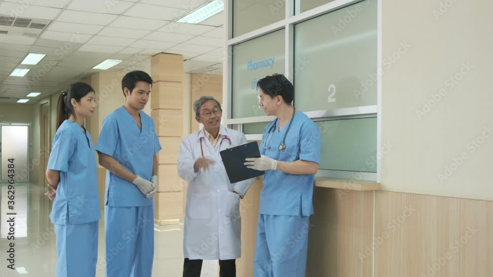 Team of asian doctor nurse consult together on patients file at hospital. Medical staff analyzing report and working at hospital. Male senior doctor having discussion in a hospital health concept Team of asian doctor nurse consult together on patients file at hospital. Medical staff analyzing report and working at hospital. Male senior doctor having discussion in a hospital health concept