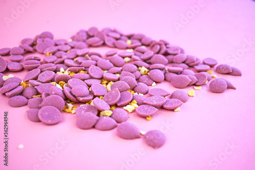 Pink chocolate drops scattered on pink background. Tablet for confectionary. Ruby chocolate made from ruby cocoa bean.