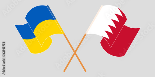 Crossed and waving flags of the Ukraine and Bahrain