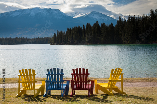 Multi-colored adirondack lawn chairs on the lawn in front of Jasper Lake Lodge, Jasper, Alberta, Canada. © Bob