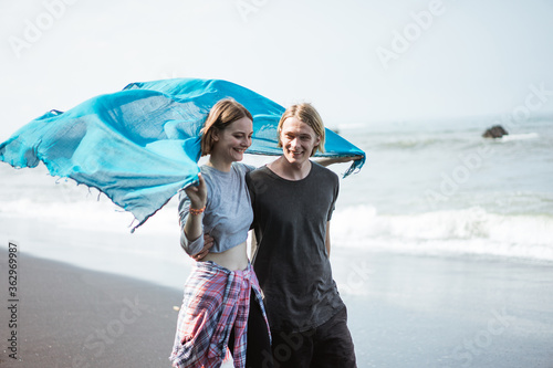 Young couple enjoy a trip together on the beach in the bright sunny day photo