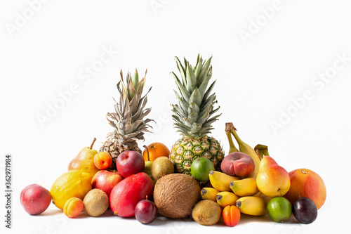 Tropical fruits assortment isolated on white background. Pineapples, coconut, bananas, mango, apples, kiwi, lime, lemon, pear, apricots, peaches and plum.