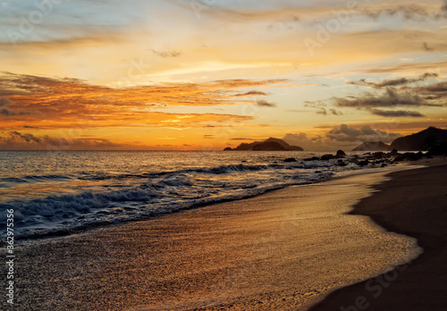 romantic sunset on beach at seychelles island glittering surf and ocean water